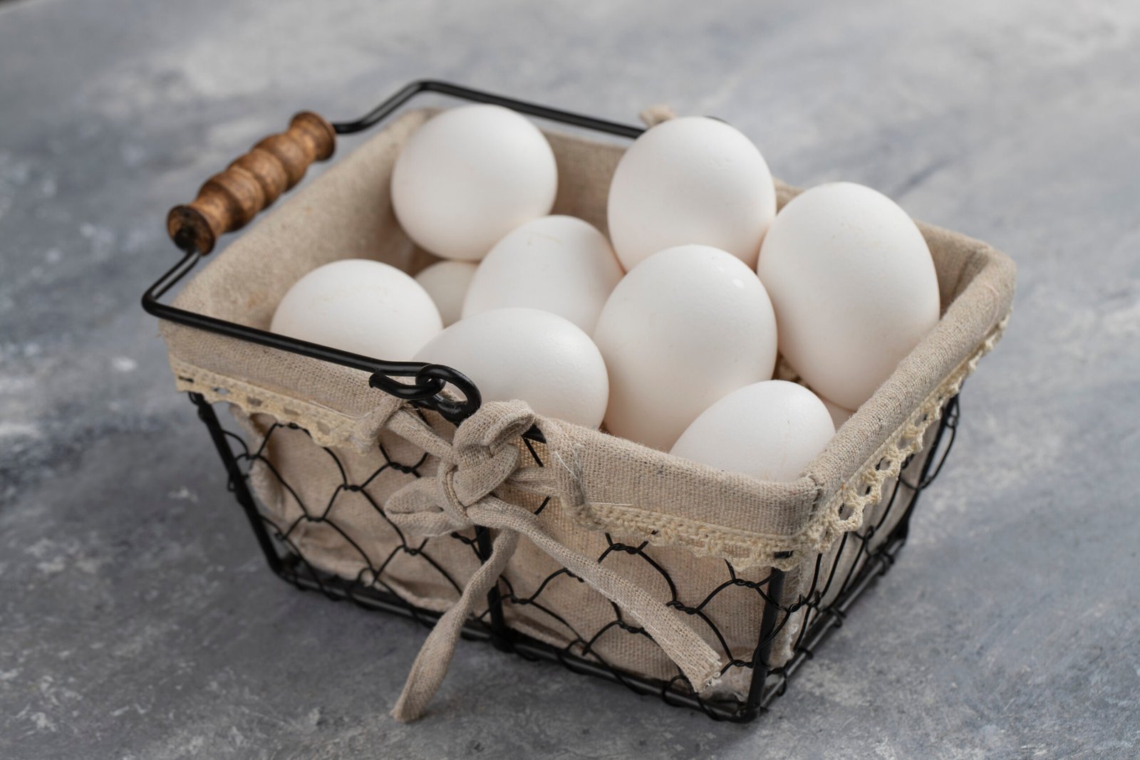 Basket full of fresh white chicken eggs on a marble background . High quality photo